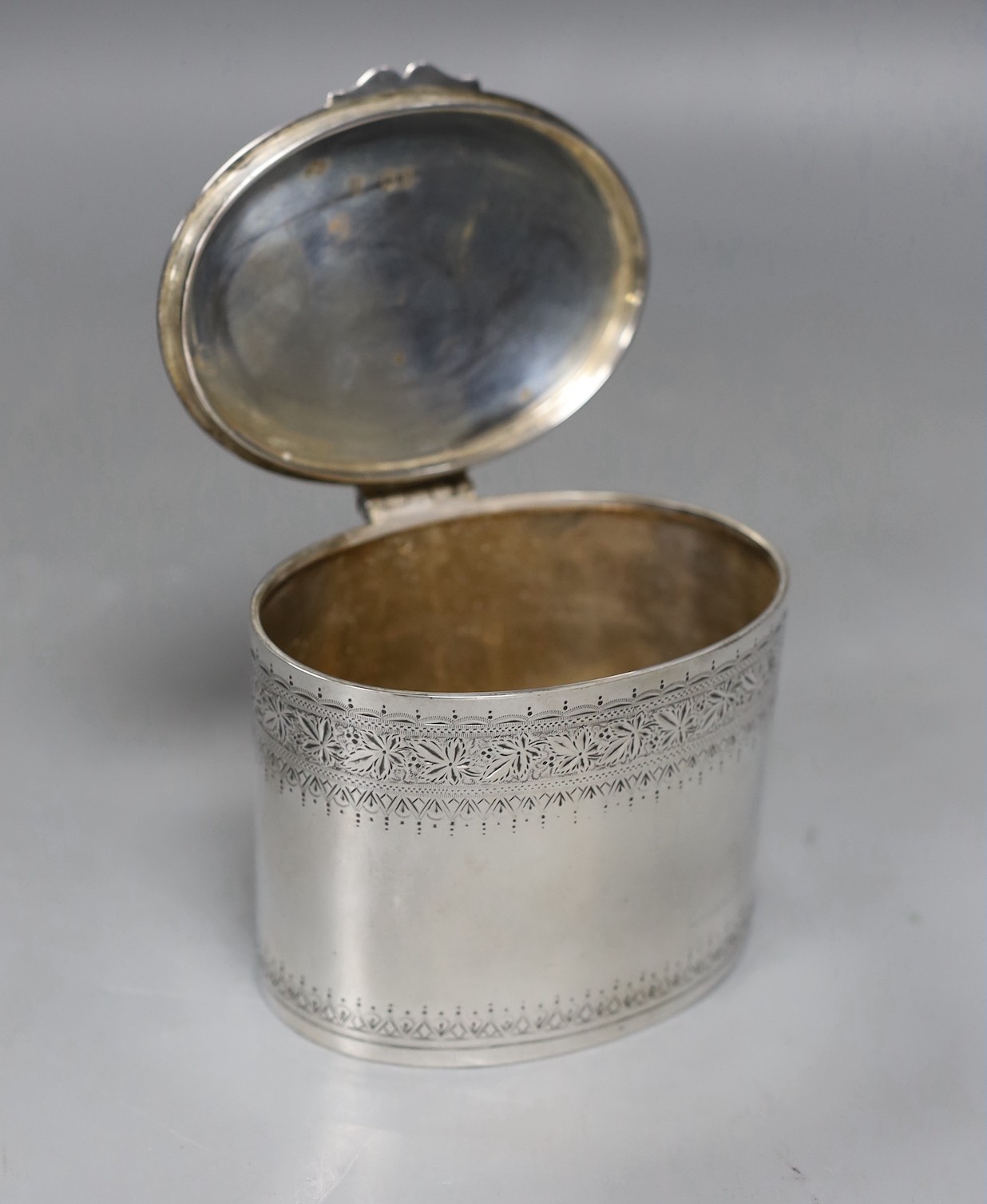 A late Victorian engraved silver oval tea caddy, Edward Hutton, London, 1891, height 74mm, 6.6oz.